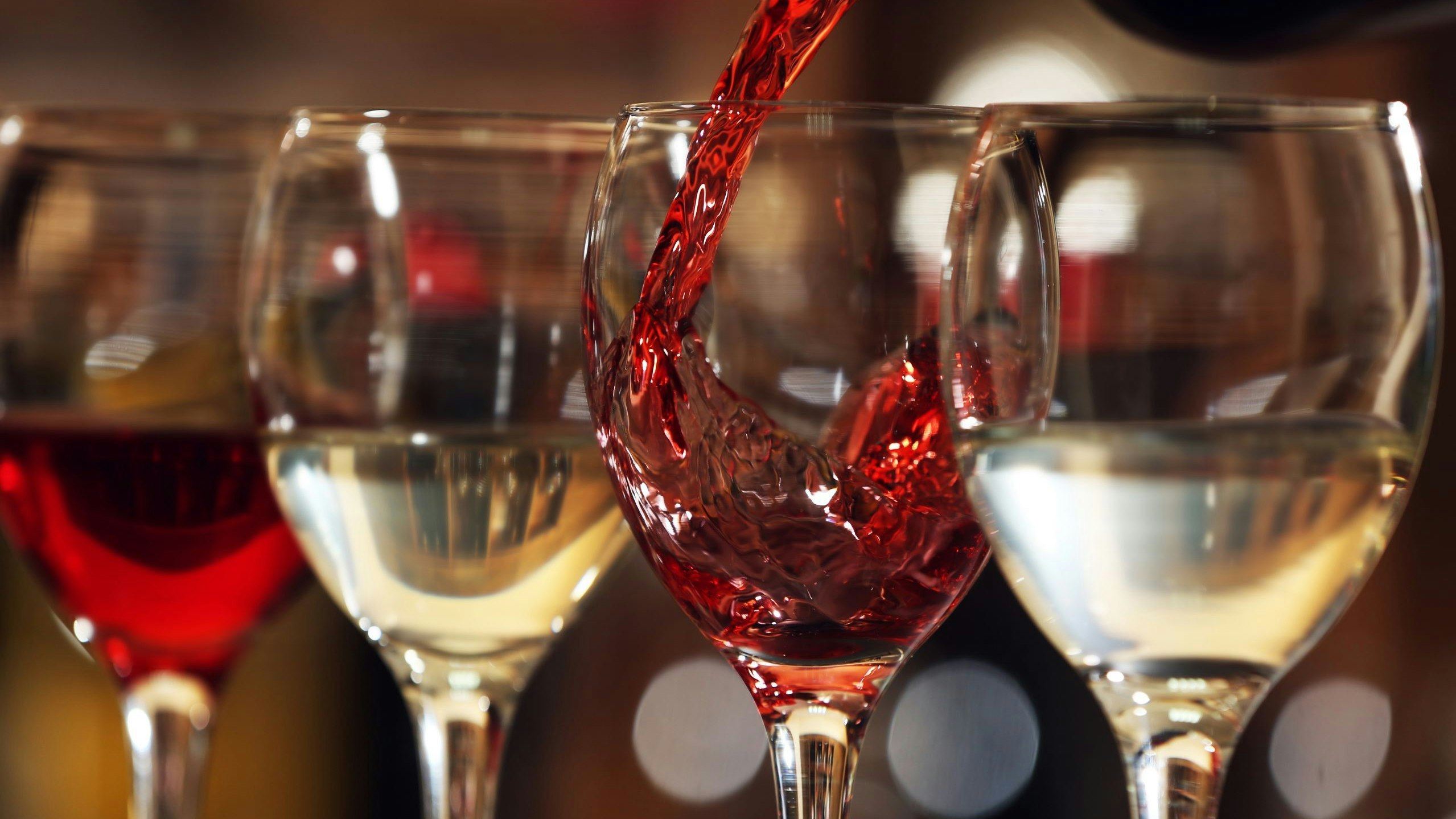 Quatre verres remplis avec du vin rouge et blanc
